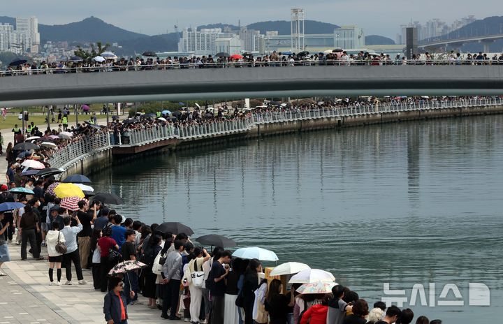  [부산=뉴시스] 하경민 기자 = 추석 연휴 마지막날인 27일 부산 동구 북항 친수공원에서 시민들이 수로에서 유영하는 상어를 구경하고 있다. '부캉이'로 불리는 이 상어가 화제를 모으면서 지난 24일 10만1000명, 25일 13만6000명, 26일 14만명 등 추석 연휴 사흘간 38만명의 관람 인파가 북항 친수공원을 방문했다. 2026.09.27. yulnetphoto@newsis.com