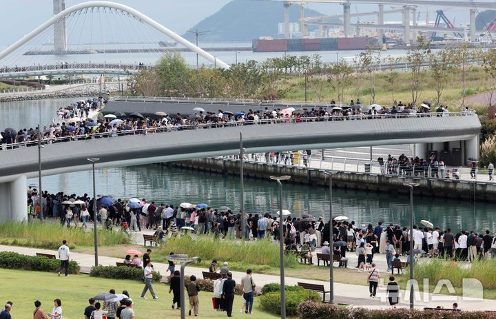  [부산=뉴시스] 하경민 기자 = 추석 연휴 마지막날인 27일 부산 동구 북항 친수공원에서 시민들이 수로에서 유영하는 상어를 구경하고 있다. '부캉이'로 불리는 이 상어가 화제를 모으면서 지난 24일 10만1000명, 25일 13만6000명, 26일 14만명 등 추석 연휴 사흘간 38만명의 관람 인파가 북항 친수공원을 방문했다. 2026.09.27. yulnetphoto@newsis.com