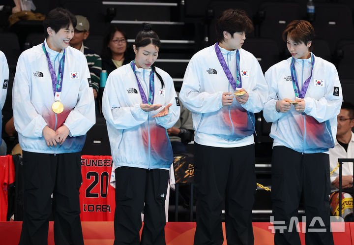 [이나자와(일본)=뉴시스] 황준선 기자 = 27일(현지 시간) 일본 아이치현 이나자와시 엔트리오에서 열린 2026 아이치·나고야 아시안게임 여자 핸드볼 시상식에서 금메달을 획득한 한국 권한나와 류은희 등 선수들이 메달을 만져보고 있다. 2026.09.27. hwang@newsis.com