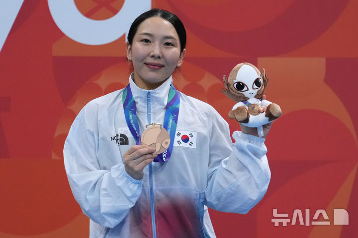 [도쿄=AP/뉴시스] 김수지가 28일 일본 도쿄 아쿠아틱스 센터에서 열린 2026 아이치·나고야 아시안게임 다이빙 여자 1m 스프링보드 시상대에 올라 동메달을 들고 포즈를 취하고 있다. 김수지는 245.05점으로 3위를 기록하며 동메달을 목에 걸었다. 2026.09.28.