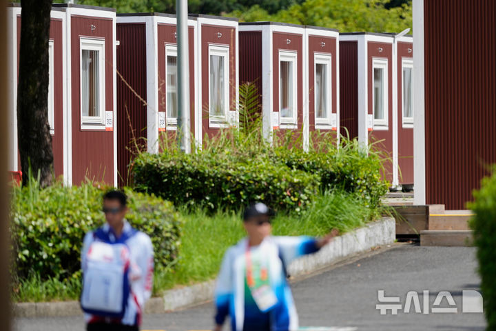 [나고야=AP/뉴시스] 아이치·나고야 아시안게임 조직위원회가 침대가 짧다는 선수들의 지적에 따라 숙소에 발 받침을 마련했다. 사진은 지난 18일 일본 나고야 아시안게임 선수촌에서 관계자들이 선수 숙소로 쓰이는 오두막형 시설 밖에 서 있는 모습. 2026.09.28.
