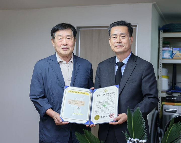 2026년 9월 22일 오전 전병희 국방부 유해발굴감식단장(오른쪽)과 고 한길진 하사의 아들 한봉진 씨(왼쪽·83)가 호국의 영웅 귀환행사에서 기념사진을 촬영하고 있다. [사진=국방부 유해발굴감식단 제공] *재판매 및 DB 금지