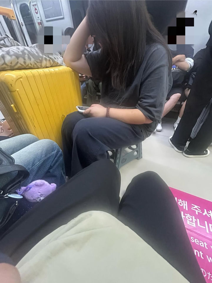[서울=뉴시스] 지하철 객실 통로에 의자를 펴고 앉아 있는 중국인 관광객 일행이 포착됐다. 사진 스레드 캡처