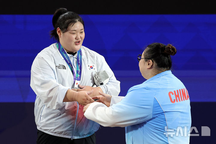 [나고야(일본)=뉴시스] 이영환 기자 = 29일 오후(현지 시간) 일본 아이치현 나고야시 중소기업진흥회관에서 열린 2026 아이치·나고야 아시안게임 역도 여자 86kg 이상급 시상식에서 은메달을 획득한 한국 박혜정이 금메달을 획득한 중국 리원원에게 축하를 받고 있다. 2026.09.29. 20hwan@newsis.com