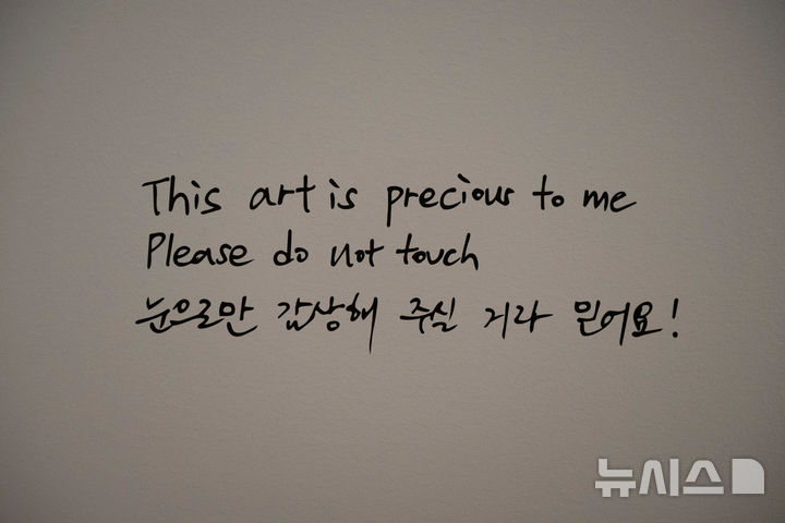 [샌프란시스코=AP/뉴시스] 29일(현지 시간) 미 캘리포니아주 샌프란시스코 현대미술관(SFMOMA)에서 열리는 방탄소년단(BTS)의 RM의 ‘RM X SFMOMA: 당신과 나 사이’ 특별 전시회 사전 공개 행사에서 RM이 벽에 쓴 글이 보이고 있다. RM의 개인 소장품을 전시하는 이번 특별전은 다음 달 3일 개막해 2월 7일까지 열린다. 2026.09.30.