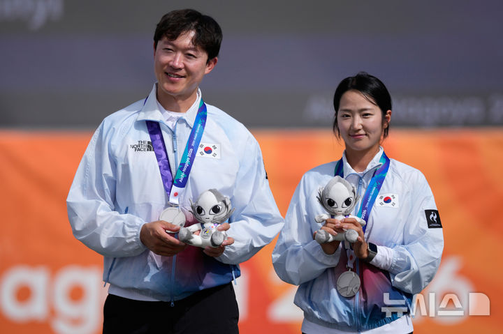 [오카자키=AP/뉴시스] 최용희(왼쪽)와 박정윤이 30일 일본 오카자키에서 열린 2026 아이치·나고야 아시안게임 양궁 컴파운드 혼성 시상식에서 은메달을 목에 걸고 기념 촬영을 하고 있다. 한국은 결승에서 인도와 157-157로 비긴 뒤 슛오프에서 19-20으로 아깝게 지면서 은메달을 차지했다. 2026.09.30.