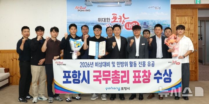 [포항=뉴시스] 경북 포항시가 30일 행정안전부 주관 비상 대비·민방위 활동 진흥 유공으로 국무총리 표창장을 받은 후 박용선 시장과 안전총괄과 직원들이 기념 촬영하고 있다. (사진=포항시 제공) 2026.09.30. photo@newsis.com