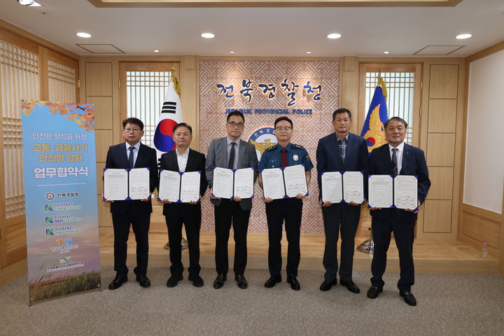[전주=뉴시스] 30일 전북 전주시 전북경찰청 청사에서 전북경찰과 도내 교통 유관기관 간 업무협약식을 진행한 뒤 참석자들이 협약서를 펼쳐보이고 있다. (사진=전북경찰청 제공) 2026.09.30. photo@newsis.com *재판매 및 DB 금지