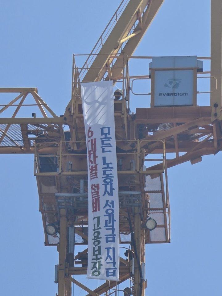 [거제=뉴시스] 신정철 기자= 강인석 전국금속노동조합 거제통영고성조선하청지회 지회장 등 조합원 6명은 30일 오후 12시 30분께 경남 거제시 한화오션 서문 인근 크레인과 공장 지붕 두 곳에서 "단체교섭 챙취"를 내걸고 고공농성에 돌입했다.사진은 한화오션 서문 인근 크레인 고공농성 모습.(사진=금속노조 거제통영고성조선하청지회 제공).2026.09.30. photo@newsis.com *재판매 및 DB 금지