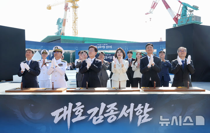 [울산=뉴시스] 조성봉 기자 = 이재명 대통령과 김혜경 여사가 30일 울산에서 열린 대호김종서함 진수식에서 안전항해 기원의식인 샴페인 브레이킹을 보며 박수를 치고 있다. 왼쪽부터 김영도 조선명장, 김경률 해군참모총장, 이 대통령, 김 여사, 정기선 HD현대 회장, 이용철 방위사업청장. 2026.09.30. suncho21@newsis.com