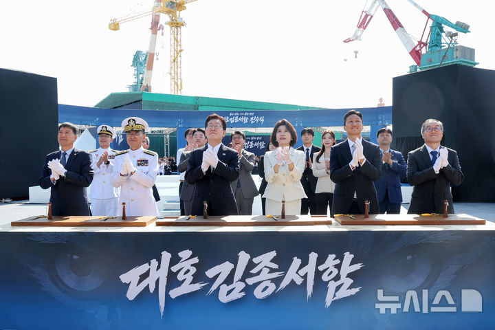 [울산=뉴시스] 조성봉 기자 = 이재명 대통령과 김혜경 여사가 30일 울산에서 열린 대호김종서함 진수식에서 안전항해 기원의식인 샴페인 브레이킹을 보며 박수를 치고 있다. 왼쪽부터 김영도 조선명장, 김경률 해군참모총장, 이 대통령, 김 여사, 정기선 HD현대 회장, 이용철 방위사업청장. 2026.09.30. suncho21@newsis.com