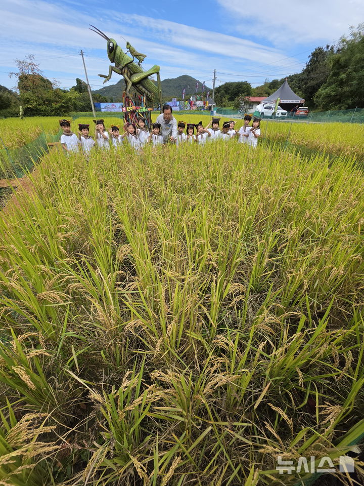 [완주=뉴시스] 김얼 기자 = 제14회 완주와일드&로컬푸드축제 개막을 하루 앞둔 1일 전북 완주군 고산자연휴양림 완주와일드&로컬푸드축제 행사장을 찾은 유희태(가운데) 완주군수가 어린이들과 함께 메뚜기 잡기 체험을 하고 있다. 2026.10.01. pmkeul@newsis.com