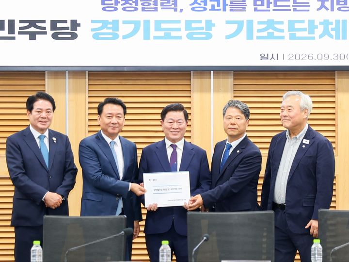 [광명=뉴시스] 박승원 광명시장(사진 가운데)이 9월30일 국회의원회관 제2세미나실에서 열린 더불어민주당 경기도당 기초단체장 예산정책간담회에서 이광재 국회 예결위원장(사진 왼쪽에서 두번째)에게 건의문을 전달하고 있다. 사진 맨 왼쪽 최대호 안양시장, 왼쪽 네번째 서영석 경기도당위원장, 맨 오른쪽 이재강 경기도당 수석부위원장. (사진=광명시 제공) 2026.10.01. photo@newsis.com *재판매 및 DB 금지