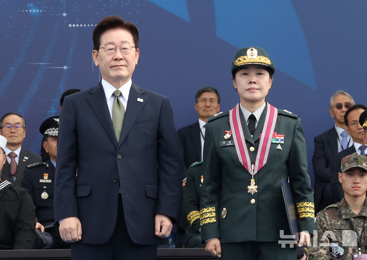 [계룡=뉴시스] 조성봉 기자 = 이재명 대통령이 1일 충남 계룡대 활주로에서 열린 제78회 국군의 날 기념식에서 석연숙 육군 제2작전사령부 육군 준장에게 보국훈장 천수장을 수여한 뒤 기념촬영 하고 있다.2026.10.01. suncho21@newsis.com