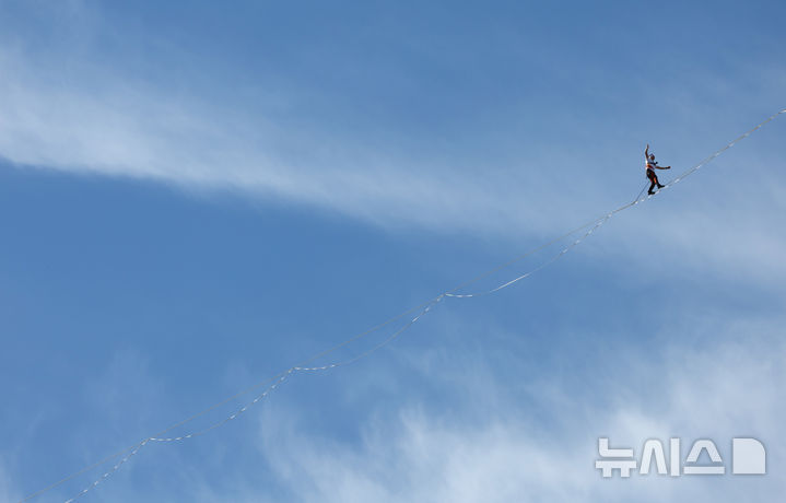 [서울=뉴시스] 전신 기자 = 세계적인 '슬랙라인' 선수 얀 루스가 1일 서울 세종대로 상공에서 퍼포먼스를 하고 있다. 2026.10.01. photo1006@newsis.com