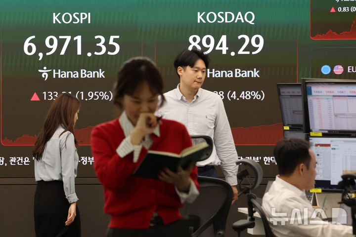 [서울=뉴시스] 권창회 기자 = 1일 오후 서울 중구 하나은행 딜링룸에서 딜러들이 업무를 보고 있다. 코스피가 전 거래일보다 133.31포인트(1.95%) 오른 6971.35에 마감했다. 코스닥 지수는 전 거래일보다 38.38포인트(4.48%) 오른 838.41, 원·달러 환율은 전 거래일보다 5.6원 내린 1358.4원에 마감했다. 2026.10.01. kch0523@newsis.com