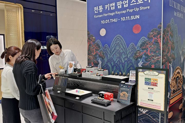 [서울=뉴시스] 고객들이 국새 키캡 키링을 보고 있는 모습. (사진=한화갤러리아 제공) 2026.10.02. photo@newsis.com *재판매 및 DB 금지