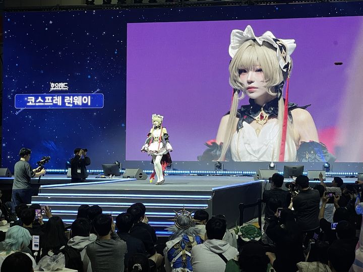 [고양=뉴시스] 이주영 기자 = 2일 경기 고양시 킨텍스 제2전시장에서 열린 호요버스 종합 게임 축제 '호요랜드2026'을 찾은 관람객들이 중앙 무대에서 코스프레 런웨이를 감상하는 모습. 2026.10.02. zoo@newsis.com *재판매 및 DB 금지