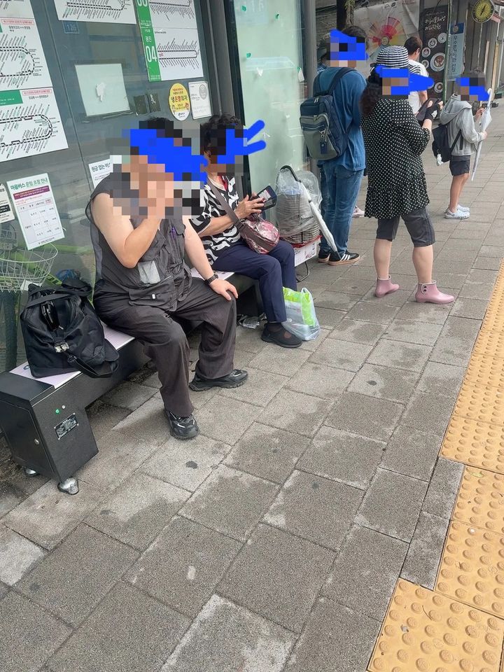 [서울=뉴시스] 버스정류장 의자에 앉아 담배를 피우고 있는 남성의 모습이다. (사진출처=스레드 캡처)