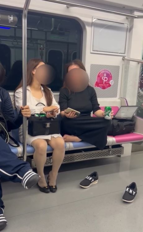 [서울=뉴시스] 지하철에서 신발을 벗고 맨발로 양반다리를 하고 있는 여성의 모습이 공개돼 논란이 되고 있다. (사진출처=스레드 캡처)