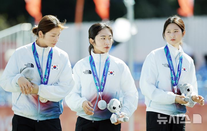 [오카자키(일본)=뉴시스] 김금보 기자 = 2일(현지 시간) 일본 아이치현 오카자키시 오카자키 중앙종합공원 내 다목적 광장에서 열린 2026 아이치·나고야 아시안게임 양궁 리커브 여자 단체 시상식에서 은메달을 차지한 강채영·이윤지·오예진이 이동하고 있다. 2026.10.02. kgb@newsis.com