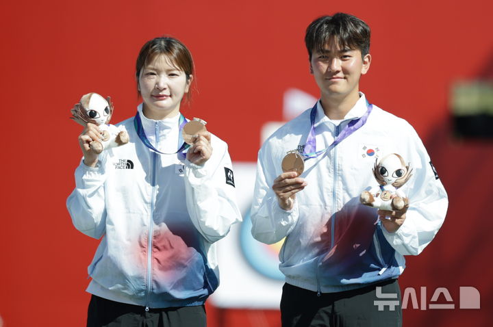 [오카자키(일본)=뉴시스] 김금보 기자 = 2일(현지 시간) 일본 아이치현 오카자키시 오카자키 중앙종합공원 내 다목적 광장에서 열린 2026 아이치·나고야 아시안게임 양궁 리커브 혼성 단체전 시상식에서 한국 김제덕과 강채영이 동메달을 목에 걸고 있다. 2026.10.02. kgb@newsis.com