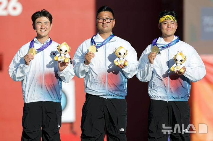 [오카자키(일본)=뉴시스] 김금보 기자 = 2일(현지 시간) 일본 아이치현 오카자키시 오카자키 중앙종합공원 내 다목적 광장에서 열린 2026 아이치·나고야 아시안게임 양궁 리커브 남자 단체 시상식에서 금메달을 획득한 김우진, 이우석, 김제덕이 기념촬영을 하고 있다. 2026.10.02. kgb@newsis.com