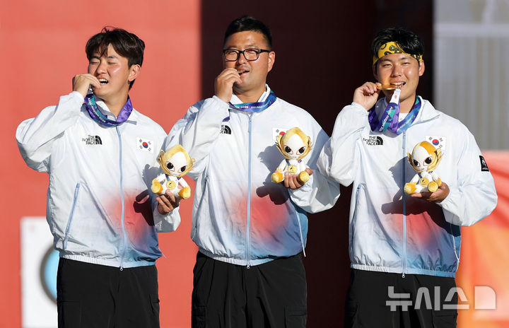 [오카자키(일본)=뉴시스] 김금보 기자 = 2일(현지 시간) 일본 아이치현 오카자키시 오카자키 중앙종합공원 내 다목적 광장에서 열린 2026 아이치·나고야 아시안게임 양궁 리커브 남자 단체 시상식에서 금메달을 획득한 김우진, 이우석, 김제덕이 기념촬영을 하고 있다. 2026.10.02. kgb@newsis.com