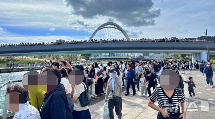 [부산=뉴시스]원동화 기자 = 3일 낮 12시 부캉이가 그물을 넘어 수로로 다시 들어오자 부캉이를 보기 위해 몰려든 시민들이 부산 북항친수공원에 몰렸다. 2026.10.03. dhwon@newsis.com 