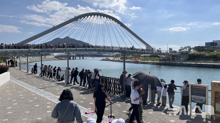 [부산=뉴시스] 이아름 기자 = 5일 오후 부산 동구 북항친수공원 4보도교 인근에 상어 '부캉이'를 보기 위한 시민과 관광객들이 몰려있다. 2026.10.05. aha@newsis.com 