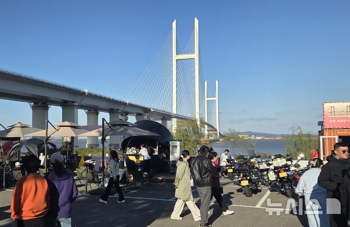 [베이징=뉴시스] 박정규 특파원 = 오는 6일 개통설이 나오고 있는 신압록강대교 북단 아래 공터에서 5일 오후 방문객들이 지나가고 있다. 2026.10.05 pjk76@newsis.com