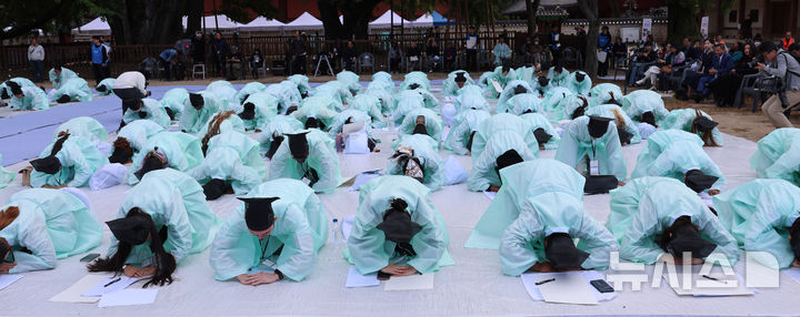 [서울=뉴시스] 권창회 기자 = 5일 서울 종로구 성균관대학교에서 열린 '제1회 재한 외국인 과거 시험'에서 참가자들이 시험에 앞서 절을 하고 있다. 2026.10.05. kch0523@newsis.com