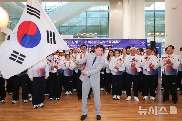 [인천공항=뉴시스] 김명년 기자 = 유승민 대한체육회장이 5일 인천국제공항 2터미널에서 열린 2026 아이치·나고야 아시안게임 대한민국 선수단 해단식에서 이상현 선수단장에게 반환 받은 단기를 흔들고 있다. 2026.10.04. kmn@newsis.com