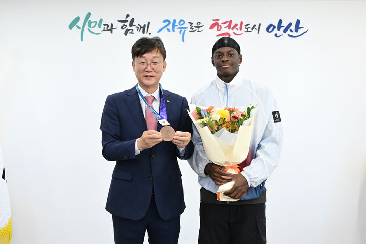 [안산=뉴시스] 이민근 안산시장이 2일 안산시청에서 '2026 아이치·나고야 아시안게임' 육상 남자 400m 계주에서 동메달을 획득한 비웨사 다니엘 가사마 선수와 기념촬영을 하고 있다. (사진=안산시 제공) 2026.10.06. photo@newsis.com *재판매 및 DB 금지
