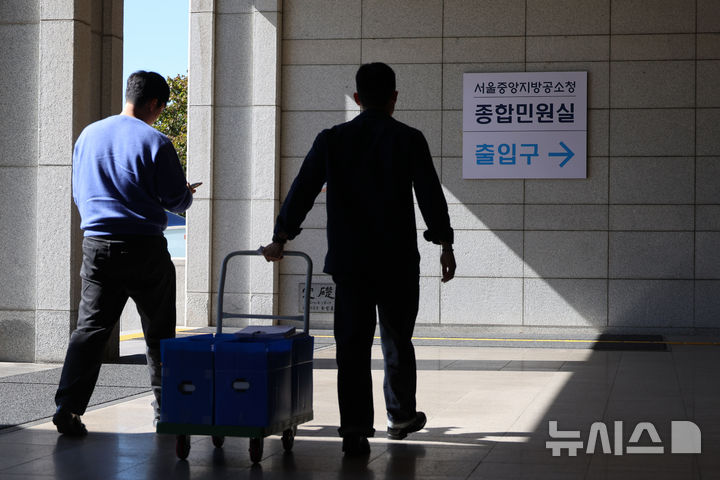 [서울=뉴시스] 고승민 기자 = 새 형사사법체계 시행으로 검찰이 직접 수사하던 미제 사건 가운데 100여건이 경찰로 넘어올 예정이다. 사진은 6일 서울중앙지방공소청에서 사건 등 서류들을 들고 이동하는 경찰 관계자들 모습.경찰에 따르면 경찰과 검찰은 검사가 직접 수사를 개시했지만 제도 전환에 따른 90일의 경과기간 안에 종결하기 어렵다고 판단한 사건 100여건을 경찰로 이송하기로 협의했다. 2026.10.06. kkssmm99@newsis.com