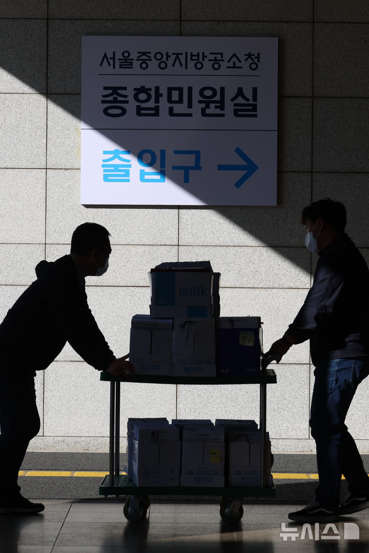 [서울=뉴시스] 고승민 기자 = 새 형사사법체계 시행으로 검찰이 직접 수사하던 미제 사건 가운데 100여건이 경찰로 넘어올 예정이다. 사진은 6일 서울중앙지방공소청에서 사건 등 서류들을 들고 이동하는 경찰 관계자들 모습.경찰에 따르면 경찰과 검찰은 검사가 직접 수사를 개시했지만 제도 전환에 따른 90일의 경과기간 안에 종결하기 어렵다고 판단한 사건 100여건을 경찰로 이송하기로 협의했다. 2026.10.06. kkssmm99@newsis.com