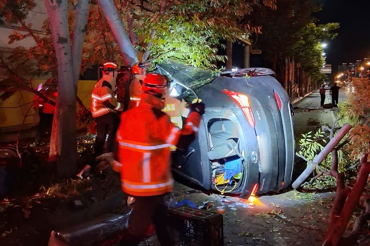 [전남광주=뉴시스] 7일 오전 0시께 전남광주 서구 매월동 한 도로에서 30대 남성 A씨가 몰던 SUV 차량이 인도 경계석을 들이받은 뒤 가로수와 가로등을 잇달아 충돌하고 옆으로 넘어졌다. (사진=전남광주 소방본부 제공) 2026.10.07. photo@newsis.com *재판매 및 DB 금지