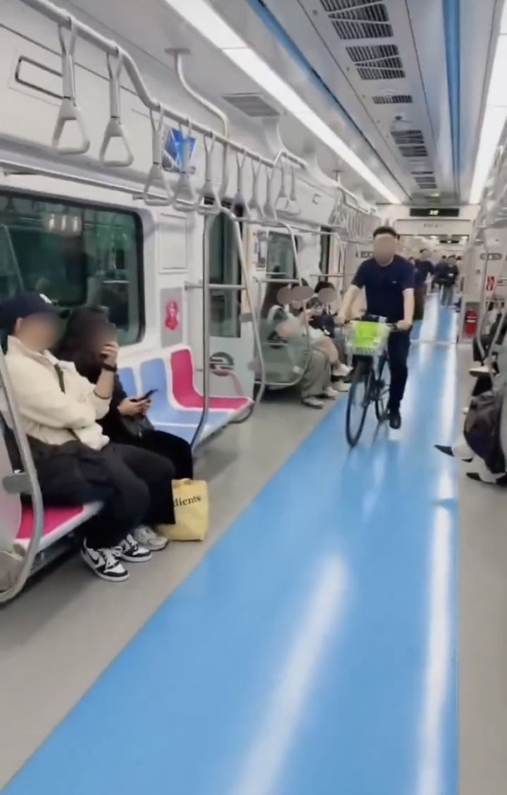 [서울=뉴시스] 한 남성이 자전거를 탄 채 지하철 승강장을 지나 객차 안으로 진입하는 모습이 포착됐다. (사진출처=X 캡처)