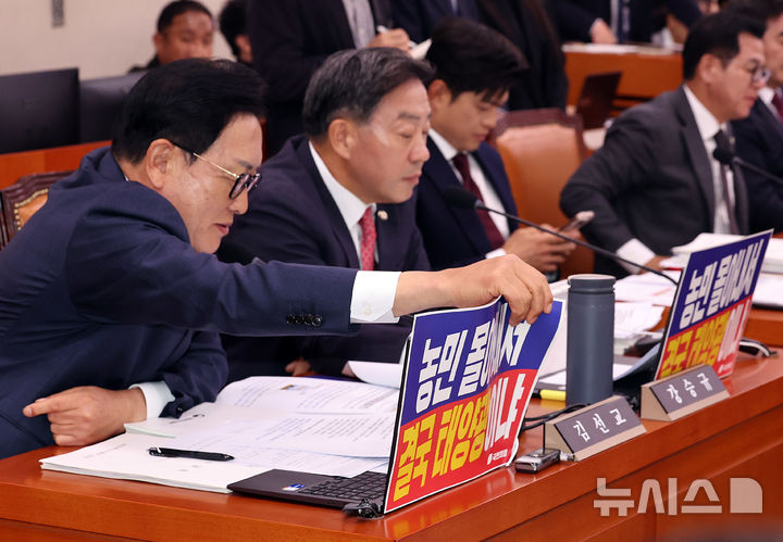 [서울=뉴시스] 최진석 기자 = 국회 농해수위 야당 간사인 김선교 국민의힘 의원이 7일 여의도 국회에서 열린 농림축산식품해양수산위원회의 농림축산식품부 등 국정감사에서 더불어민주당 의원들의 항의가 이어지자 자리에 붙은 피켓을 떼고 있다. 2026.10.07. myjs@newsis.com