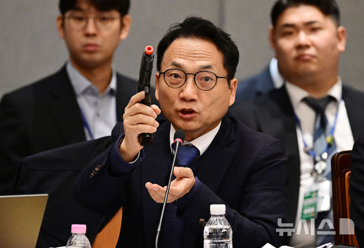 [서울=뉴시스] 국회사진기자단 = 박선원 더불어민주당 의원이 7일 서울 용산구 국방부에서 열린 국회 국방위원회의 국방부에 대한 국정감사에서 모형 권총을 들고 질의를 하고 있다. 2026.10.07. photo@newsis.com