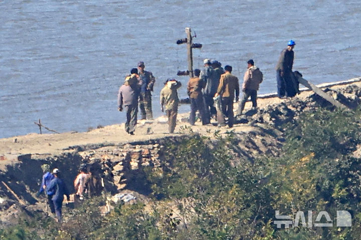 [김포=뉴시스] 김금보 기자 = 지난 7일 오후 경기 김포시 애기봉전망대에서 바라본 북한 개풍군 접경지에서 북한 주민들이 철책 및 전술도로 공사 석재를 옮기고 있다. 2026.10.07. kgb@newis.com