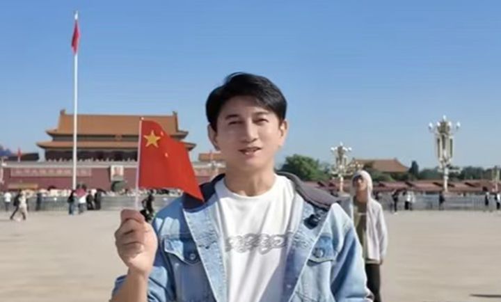 [서울=뉴시스] 대만 배우 겸 가수 우치룽이 1일 국경일에 베이징 톈안먼 광장에서 오성홍기를 흔들고 있다. 그는 이 동영상을 자신의 SNS 더우인 계정에 공개했다.(출처: 글로벌 타임스) 2026.10.08. *재판매 및 DB 금지