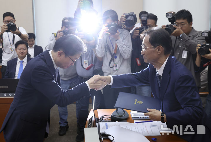 [서울=뉴시스] 김근수 기자 = 이억원 금융위원장이 8일 서울 여의도 국회에서 열린 정무위원회 국정감사에서 유동수 정무위원장에게 증인선서문을 전달하고 있다. 2026.10.08. ks@newsis.com