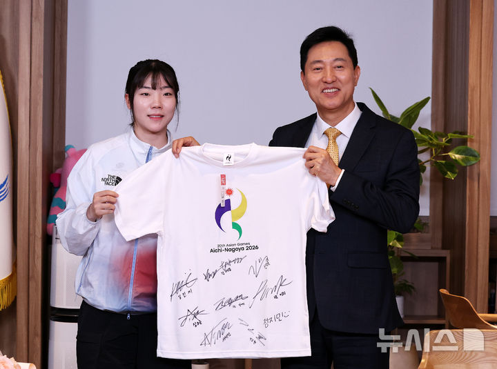 [서울=뉴시스] 홍효식 기자 = 오세훈 서울시장이 8일 서울시청에서 열린 2026 아시안게임 서울시청 소속 출전선수 오찬에 앞서 펜싱 여자 사브르 단체전 금메달리스트 전하영(서울시청)에게 선수단의 친필 사인이 담긴 아시안게임 티셔츠를 전달받으며 기념촬영하고 있다.서울시청 소속 선수단은 이번 아시안게임 7개 종목에 출전해 금메달 3개, 은메달 3개, 동메달 6개 등 역대 최다인 총 12개의 메달을 획득했다. (공동취재) 2026.10.08. photo@newsis.com
