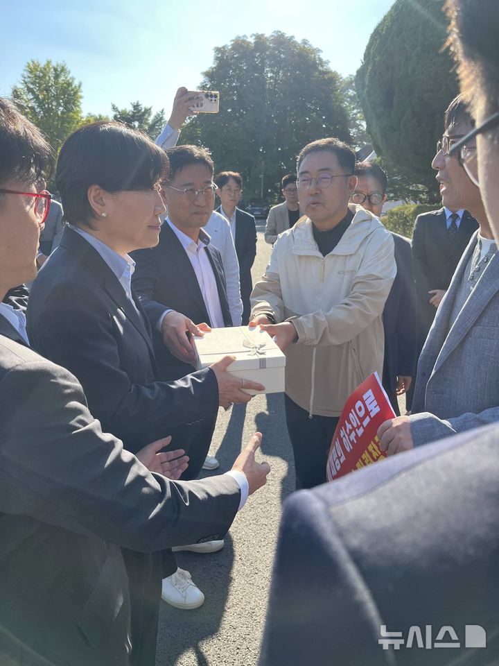 [과천=뉴시스] 과천시민들이 마사회 본관을 찾은 송미령 농림축산식품부 장관에게 지난 3월 중앙공원 삭발식 당시 잘라낸 머리카락 상자를 전달하고 있다.(사진=페이스북 캡처).2026.10.08. photo@newsis.com