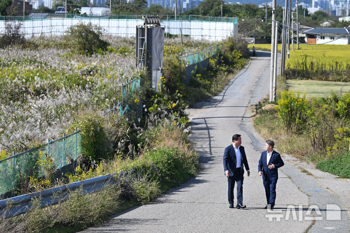 [전남광주=뉴시스] 이영주 기자 = 최태원(왼쪽) SK그룹 회장과 민형배 전남광주통합특별시장이 9일 오후 전남광주 서구 벽진동 주변 광주군공항 '호남 반도체 클러스터' 조성 예정지를 둘러보며 대화하고 있다. 2026.10.09. leeyj2578@newsis.com