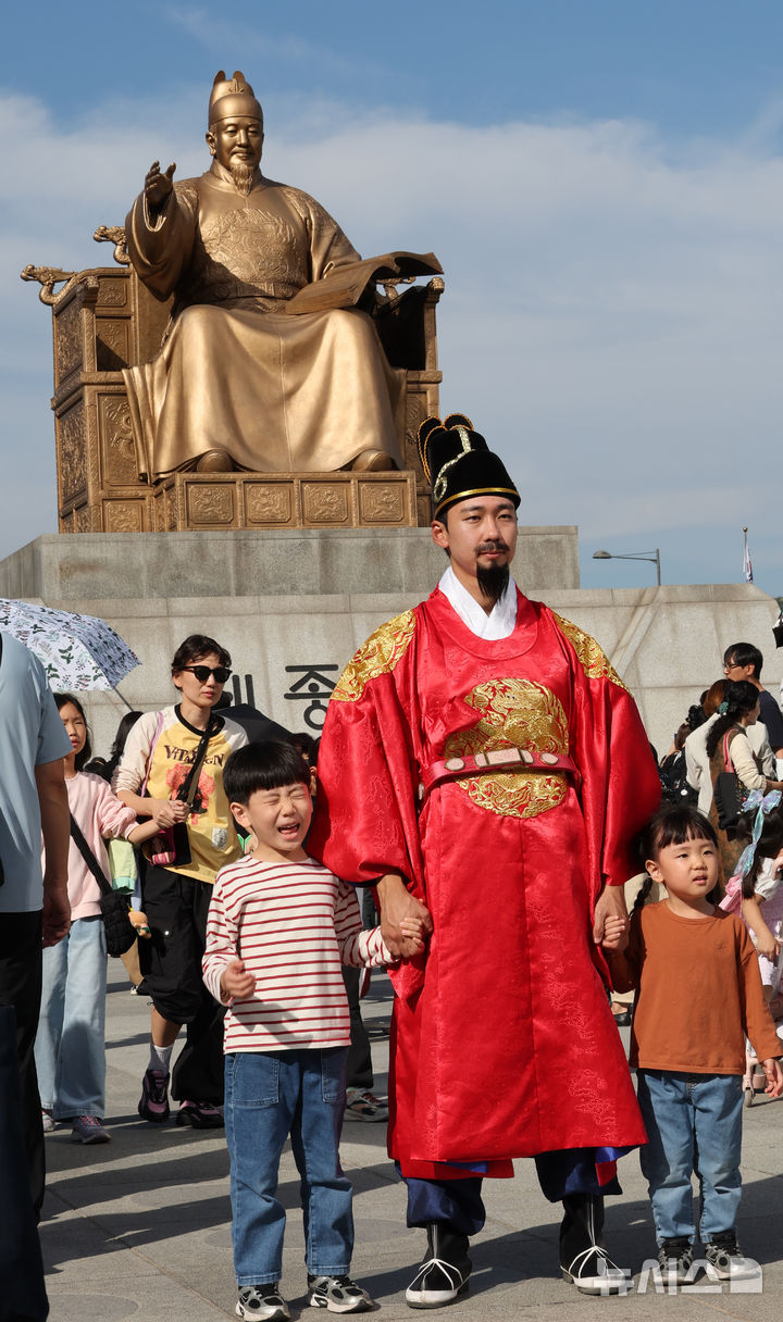 [서울=뉴시스] 박주성 기자 = 한글날 제정 100주년을 맞은 9일 서울 광화문광장 세종대왕 동상앞에서 세종대왕 복장을 한 연기자와 사진을 찍고 있다. 2026.10.09. park7691@newsis.com