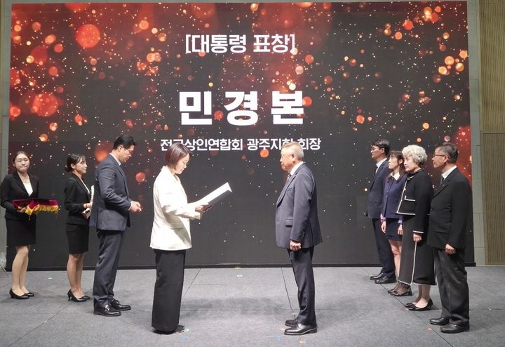 [전남광주=뉴시스] 민경본 광주상인연합회장이 9일 충남 공주에서 열린 전국우수시장박람회장에서 이소영 중소벤처기업부장관으로 대통령 표창을 받고 있다. (사진 = 광주상인연합회 제공). 2026.10.11. photo@newsis.com *재판매 및 DB 금지