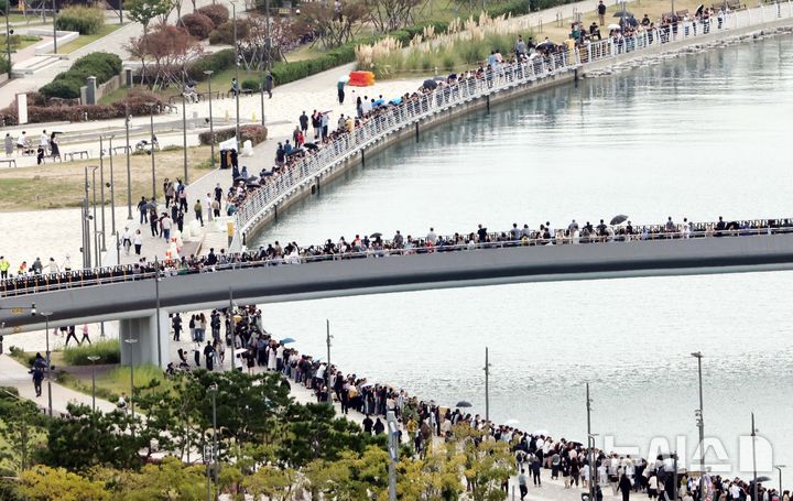  [부산=뉴시스] 하경민 기자 = 한글날 연휴 마지막날인 11일 부산 동구 북항친수공원 경관수로 일대가 흑상어 '부캉이'를 보기 위해 몰려든 시민들로 북적이고 있다. 전날 7만5000명을 포함해 지난달 19일부터 집계된 부캉이 관람 누적 방문객은 총 129만2800명으로 늘어났다. 2026.10.11. yulnetphoto@newsis.com