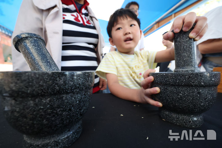 [서울=뉴시스] 김명년 기자 = 11일 오전 서울 강서구 서울식물원 진입광장 일원에서 열린 2026 허준축제에서 어린이가 약절구 체험을 하고 있다. kmn@newsis.com